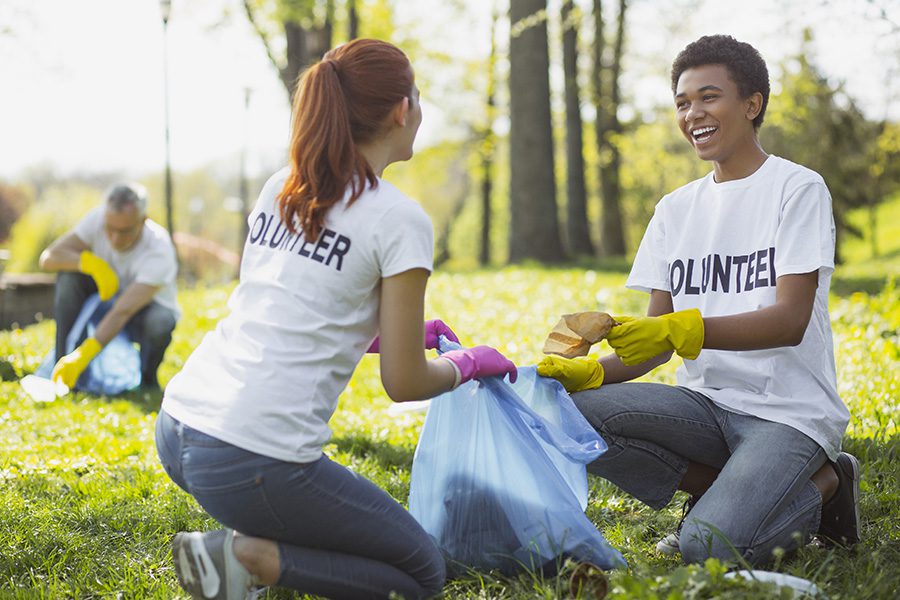 Specialized Business Insurance - Two Optimistic Volunteers Holding Garbage Bag in the Park on a Summer Day